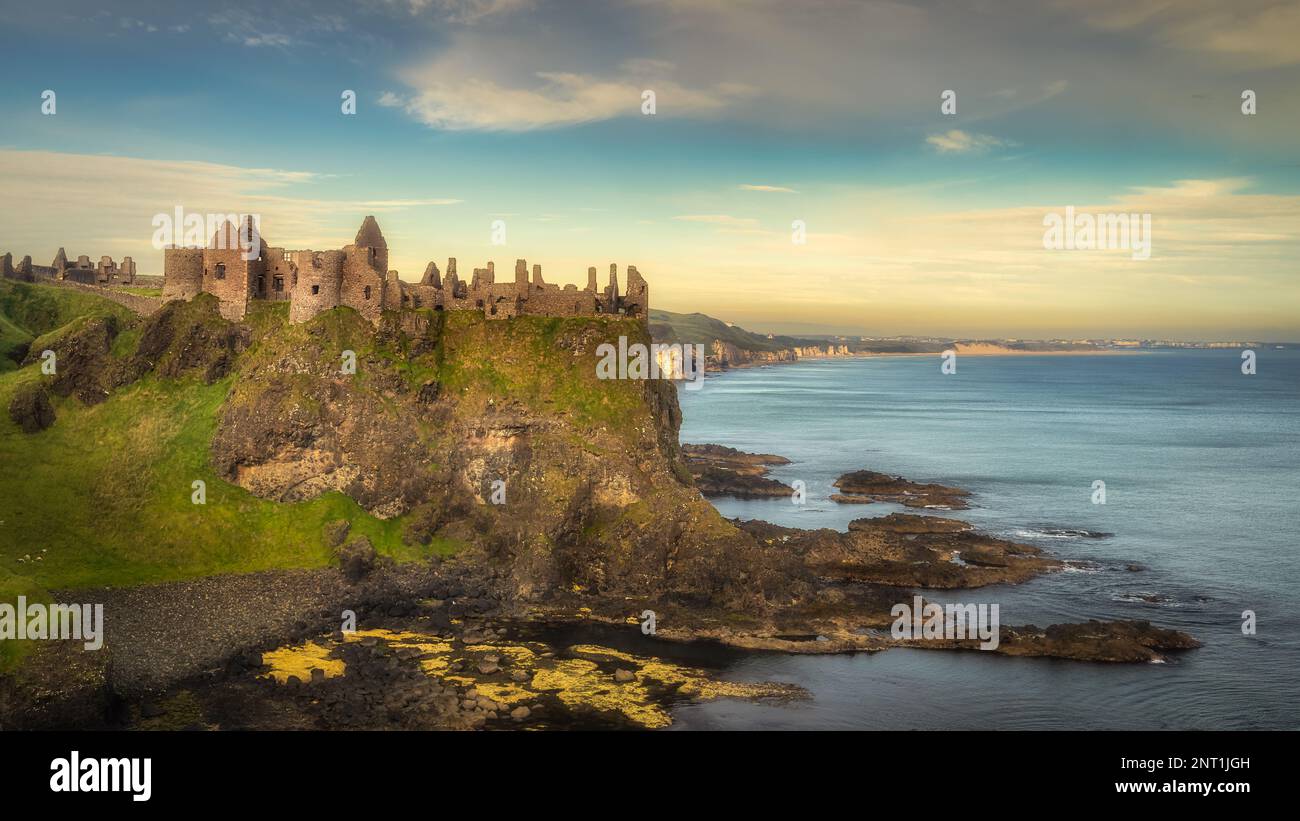 Alte Ruinen von Dunluce Castle am Rand der Klippe bei Sonnenaufgang, Bushmills, Nordirland. Drehort einer beliebten Fernsehsendung Stockfoto