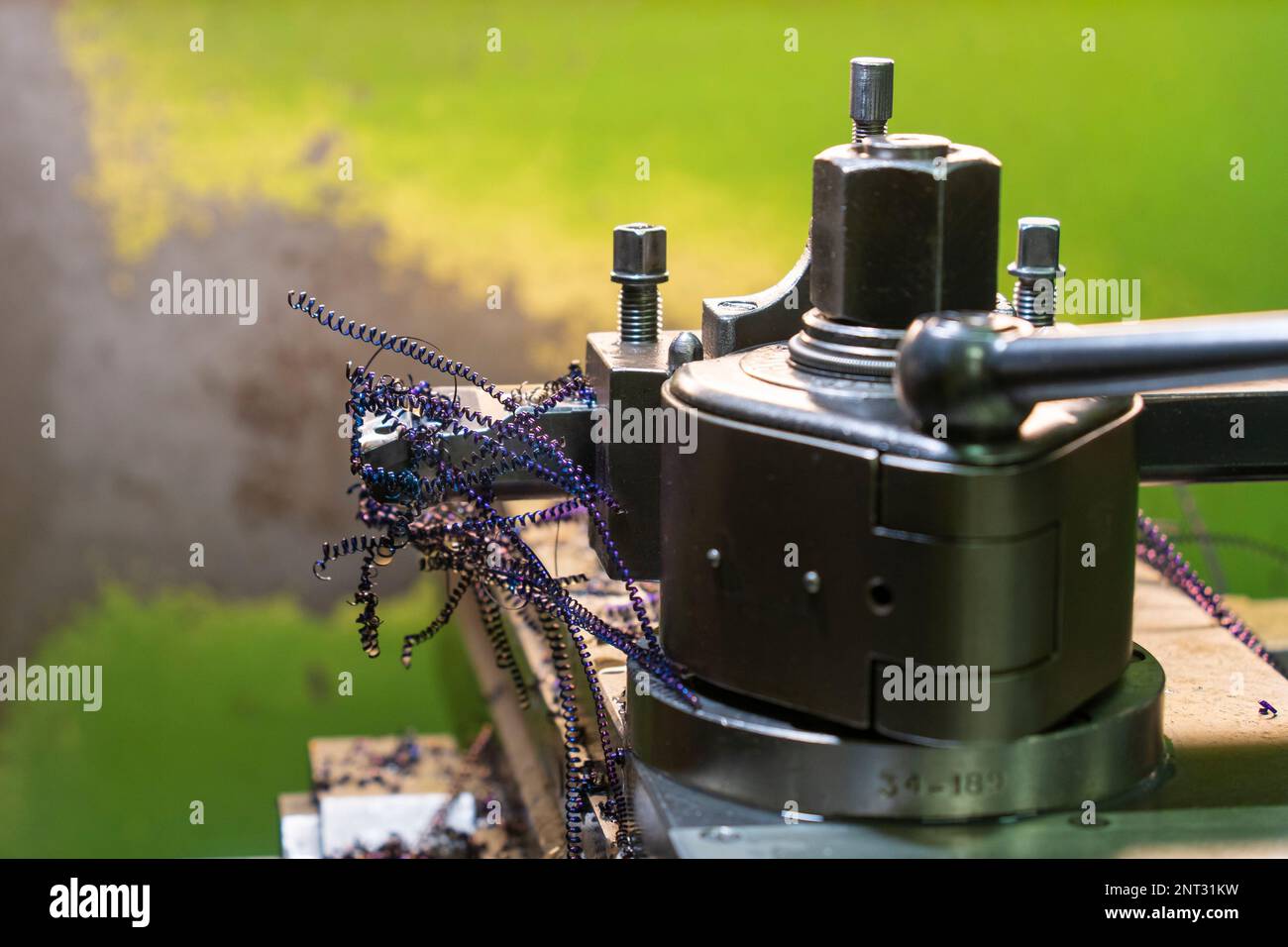 Lila Metallspäne auf einer Drehmaschine vor grünem Hintergrund Stockfoto Lila Metallspäne auf einer Drehmaschine vor grünem Hintergrund Stockfoto
