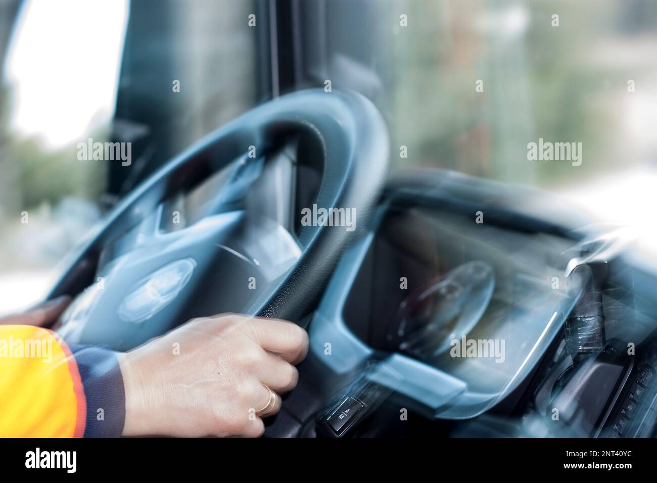 Die Hände des LKW-Fahrers halten das Lenkrad mit Bewegung, Geschwindigkeit, Bewegung, selektivem Fokus, Stockfoto