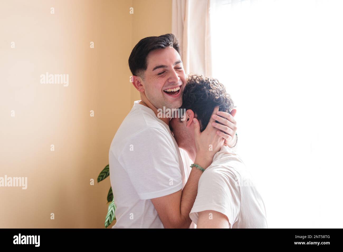 Ein junges schwules Paar, das lacht und sich romantisch umarmt und berührt. LGBT-Beziehung Stockfoto
