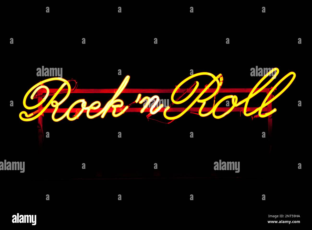 Nahaufnahme eines gelben Neonlichts, das in den Ausdruck „Rock 'n' Roll“ geformt ist. Stockfoto