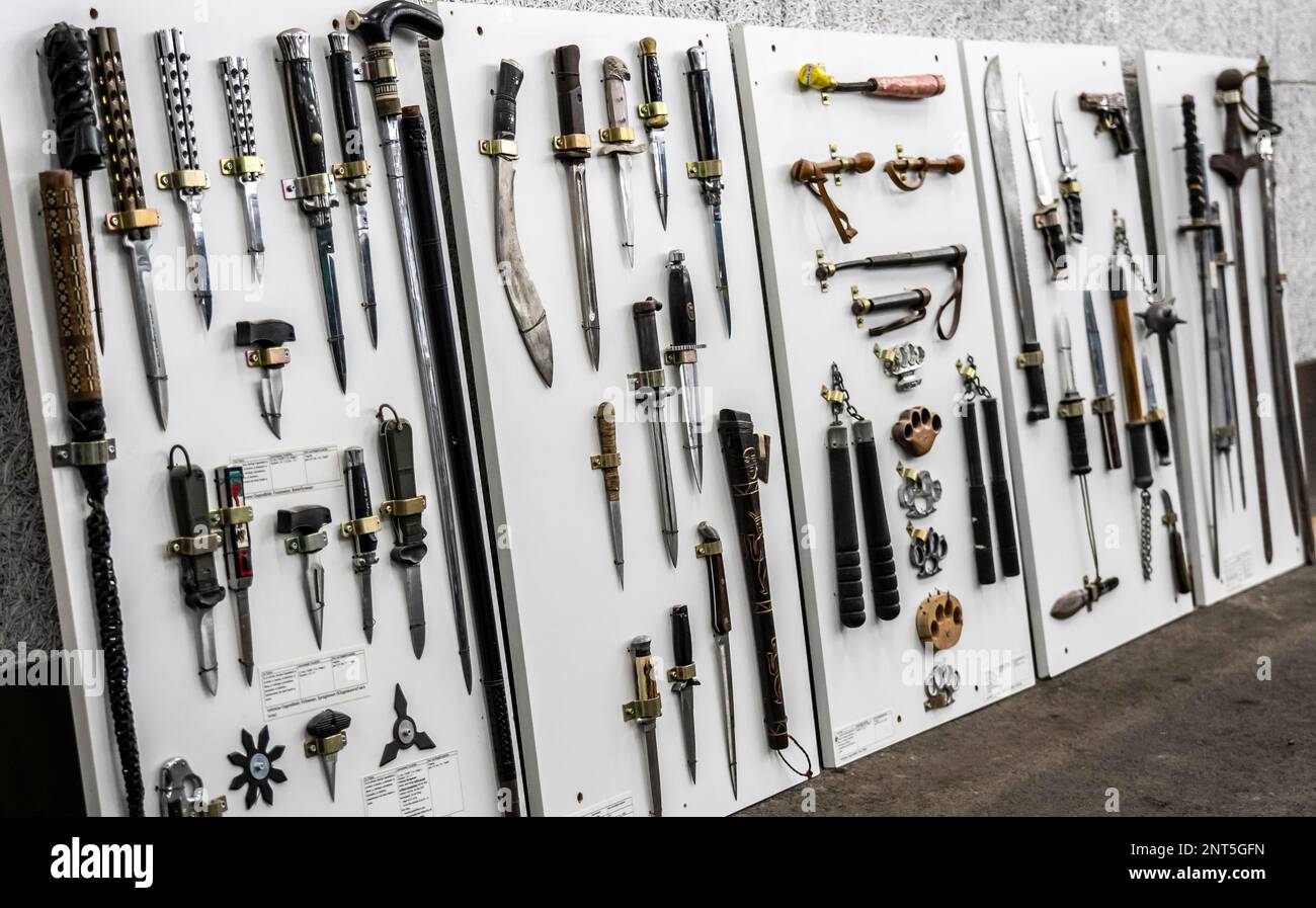 Verbotene Waffen, die von der Polizei beschlagnahmt werden, schneidet und sticht Waffen, Messer, Macheten, Springmesser, Messingschenkel, Batons, eine Darstellung der Stockfoto