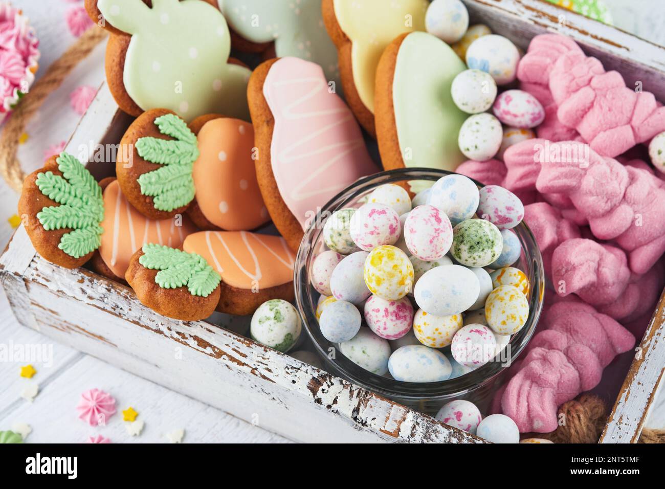 Süßes Osterkonzept. Süße Osterferien für Kinder Marshmallows Kaninchen, Schokolade ostereier, Süßigkeiten, Häschen, Snacks auf weißem Holzrücken Stockfoto