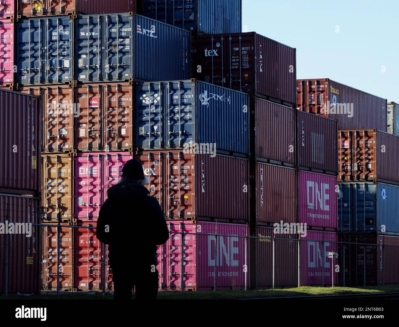 Stapel von Schiffscontainern im Hafen von Rotterdam mit Silhouetten als Beobachter. Rotterdam, Niederlande Stockfoto