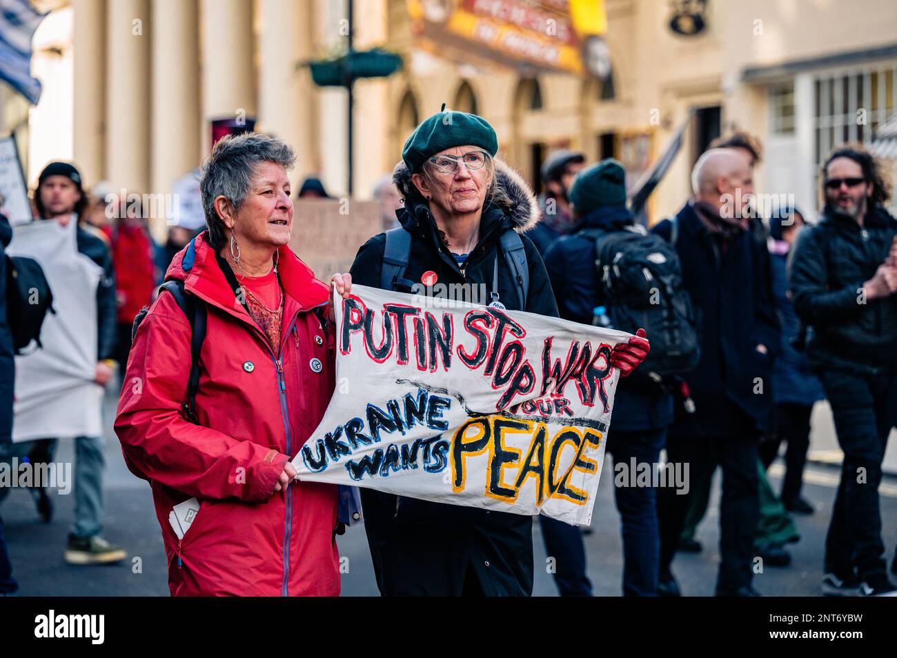 Frauen, die mit einem „Putin Stop war“-Banner auf dem „Stop the war march“ am Trafalgar Square, London, marschieren (Februar 2023). Stockfoto