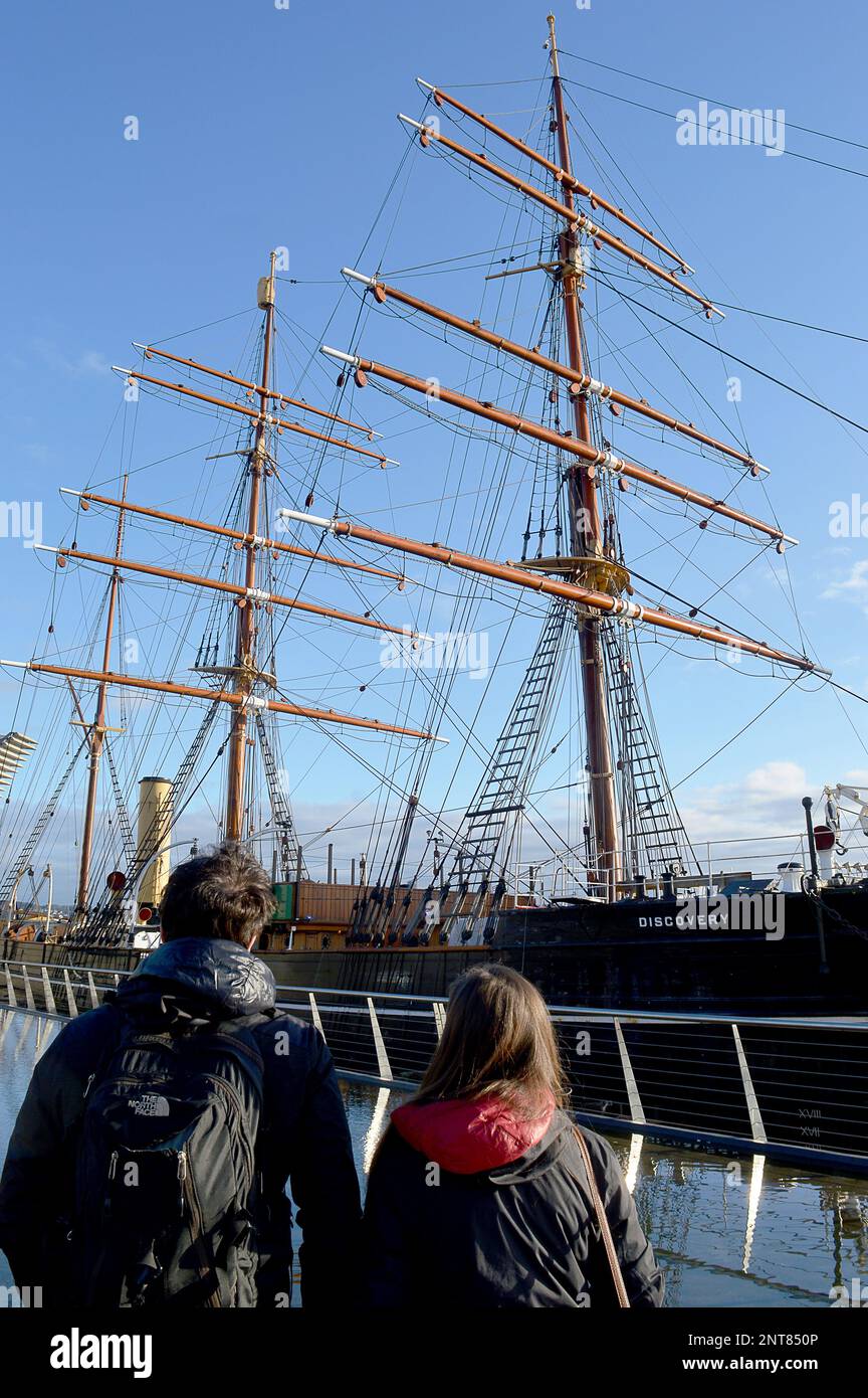 DUNDEE, SCHOTTLAND - 26. FEBRUAR 2023: Zwei Touristen sehen sich RRS Discovery an, Captain Robert Falcon Scotts Schiff, mit dem er zur Antarktis segelte Stockfoto