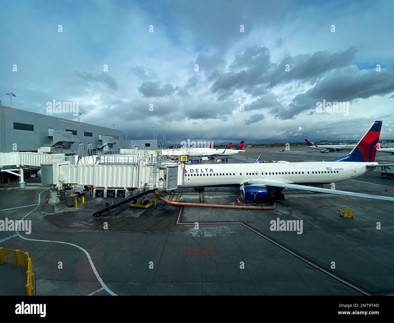 Flugzeuge von Delta Airlines warten am Gate, damit Passagiere an einem bewölkten Tag an Bord gehen können Stockfoto
