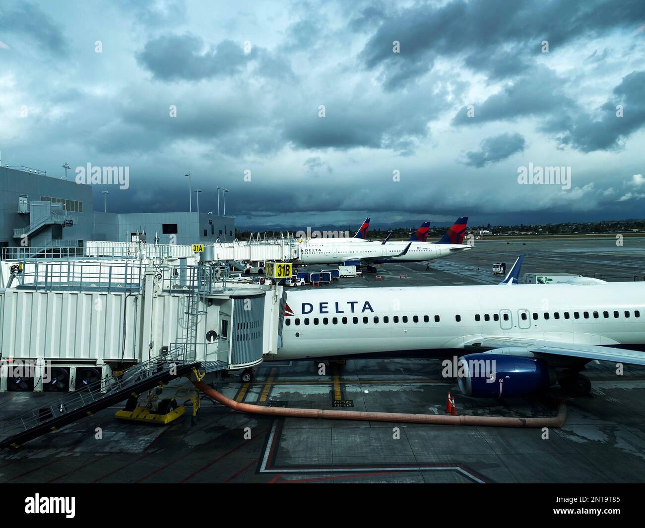 Flugzeuge von Delta Airlines warten am Gate, damit Passagiere an einem bewölkten Tag an Bord gehen können Stockfoto