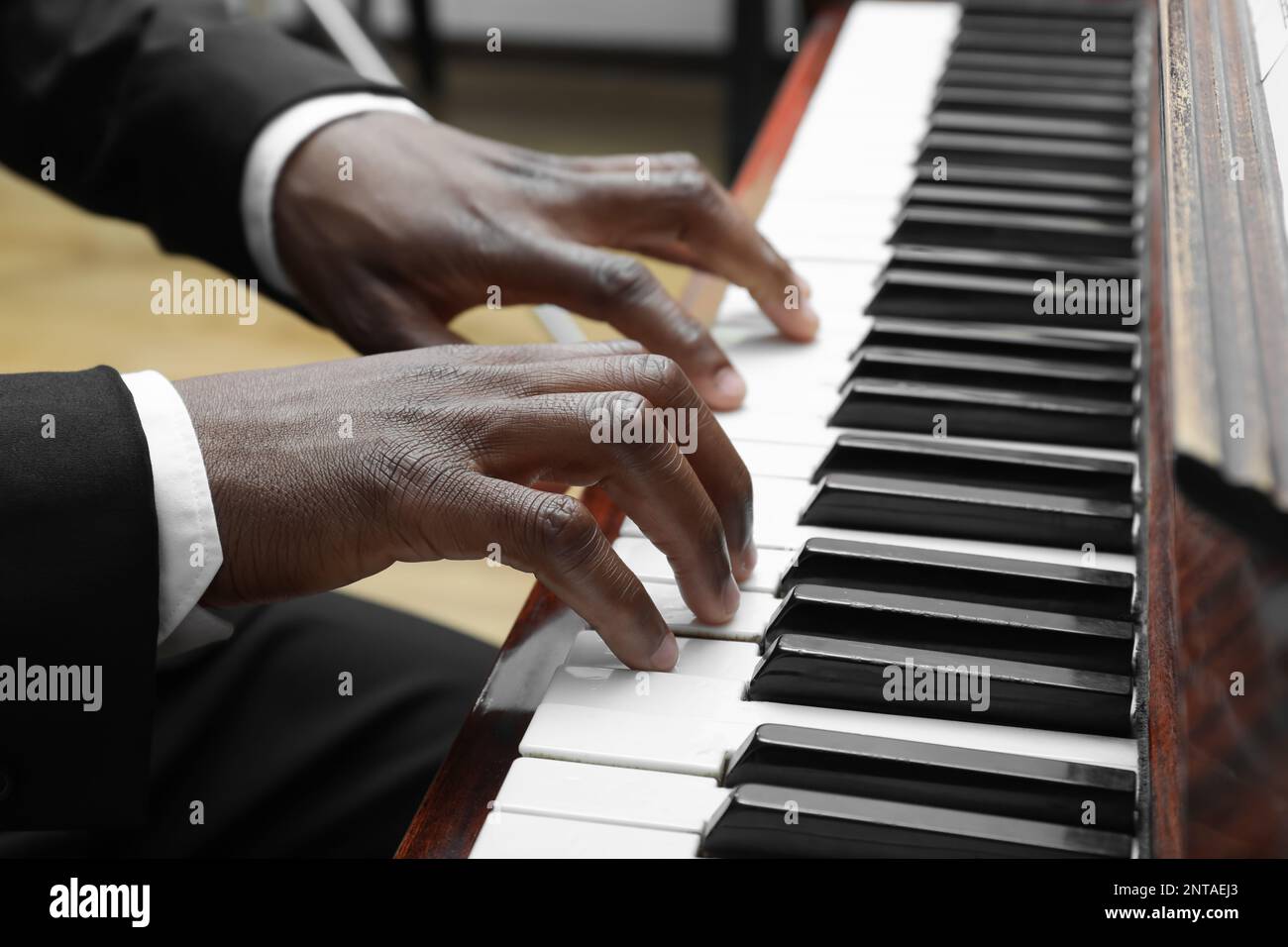 Afroamerikaner, der drinnen Klavier spielt, Nahaufnahme. Talentierter Musiker Stockfoto