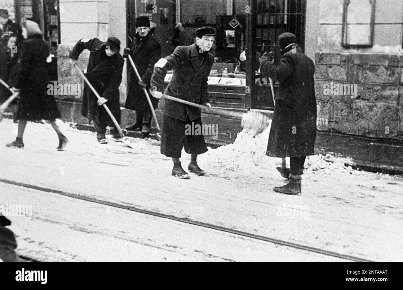 Juden, die gezwungen sind, Schnee von der Straße in Kraków zu schaufeln Stockfoto