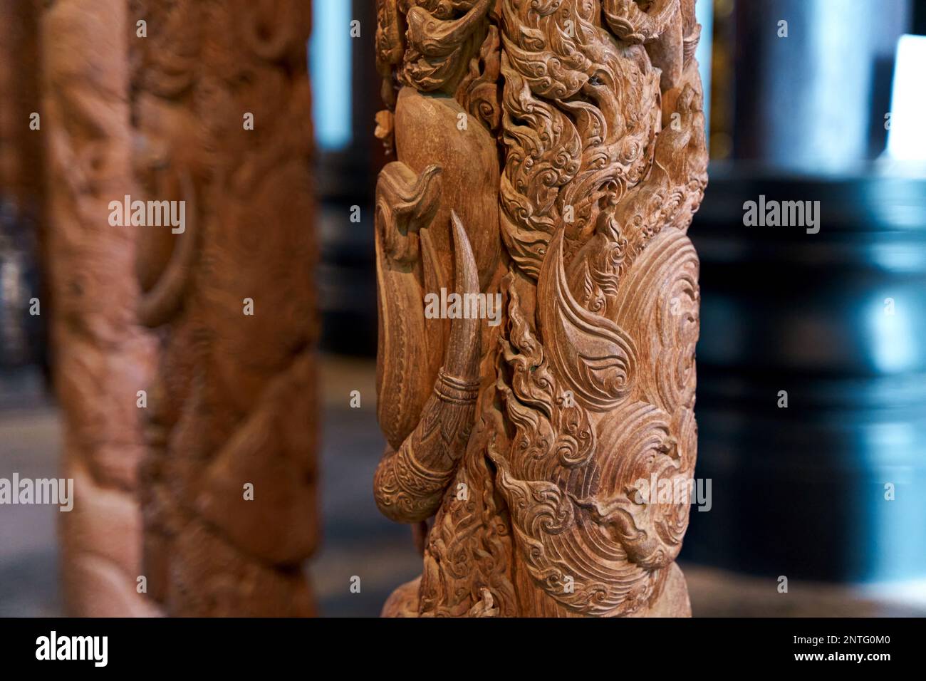 Künstlerische Holzschnitzerei: Aufwändiges Türpaneeldesign in einem thailändischen Tempel. Stockfoto