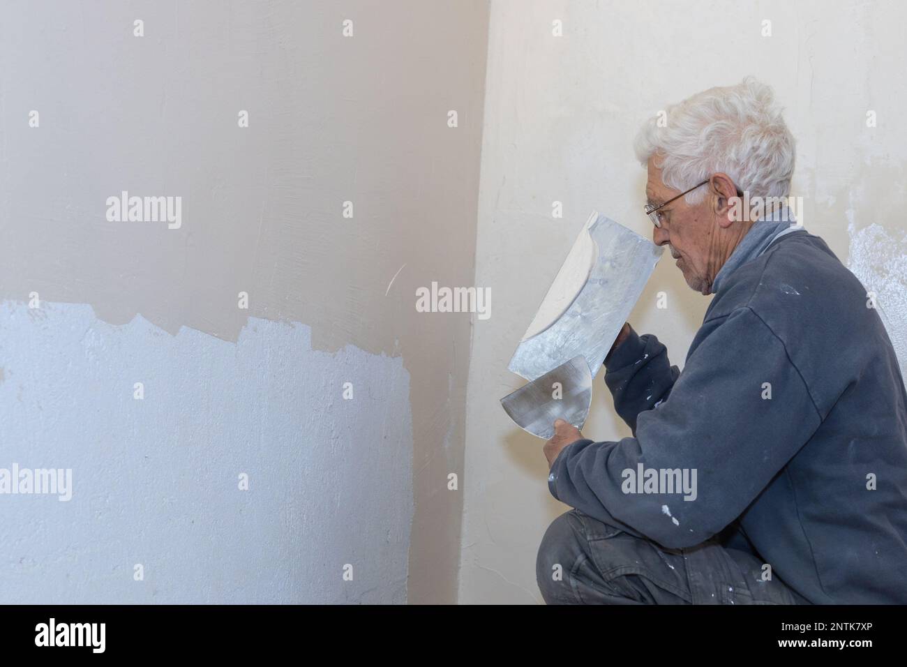 Ein Arbeiter bereitet sich darauf vor, Putz auf eine Wand aufzutragen. Stockfoto