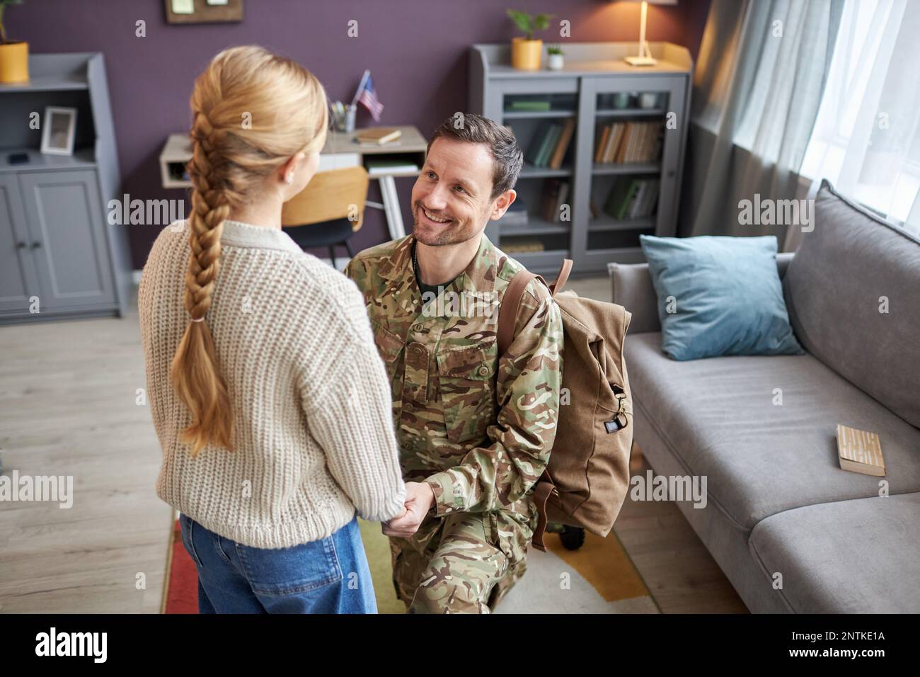 Hochwinkel-Porträt eines Militärvaters, der nach Hause kommt und mit seiner Tochter Händchen hält Stockfoto