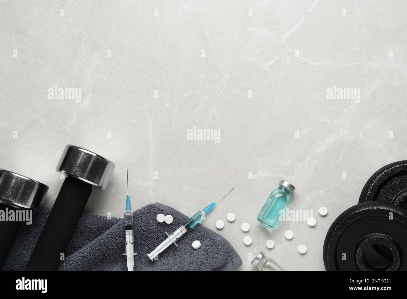 Verschiedene Drogen und Sportgeräte auf grauem Hintergrund, flach liegend mit Platz für Text. Dopingkontrolle Stockfoto