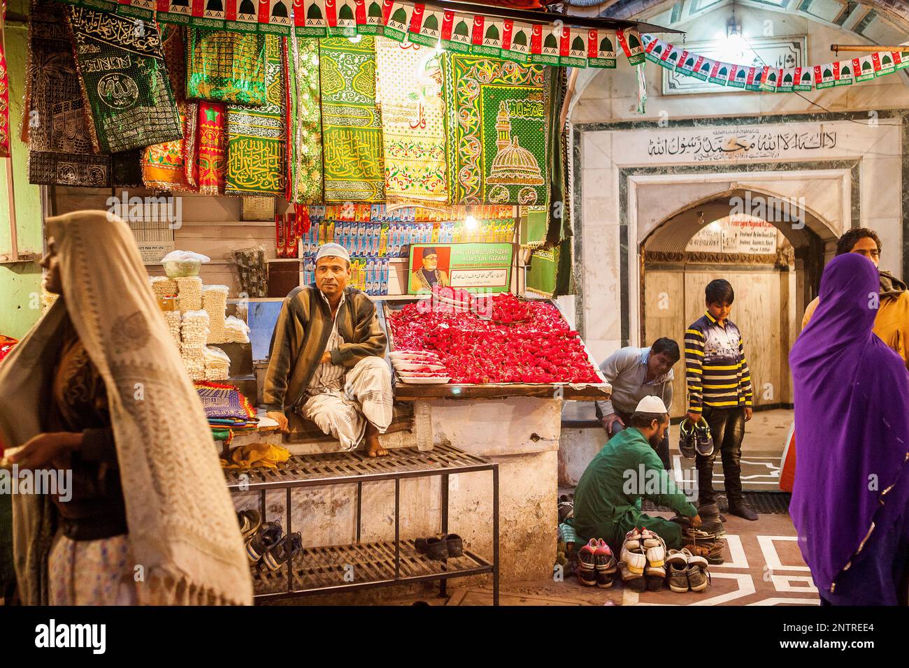 Verkäufer von religiöse Angebote, Souvenirs und Schrank für Schuhe, Eintritt ins Hazrat Nizamuddin Dargah, Delhi, Indien Stockfoto