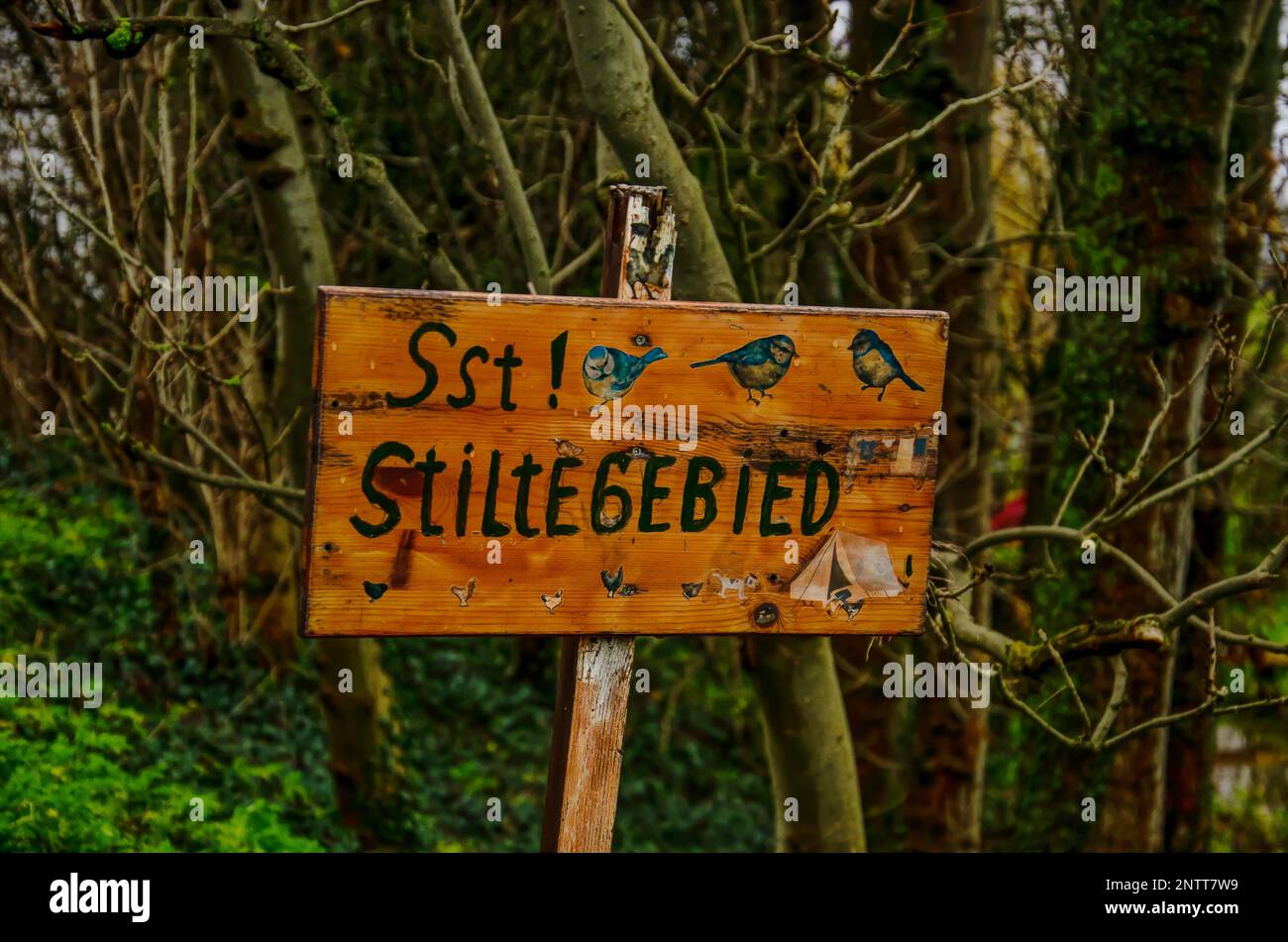 Improvisiertes Holzschild mit Bildern von Vögeln und dem Text "Stiltegebied" (ruhige Gegend auf Niederländisch) in einem kleinen Wald in den Niederlanden Stockfoto