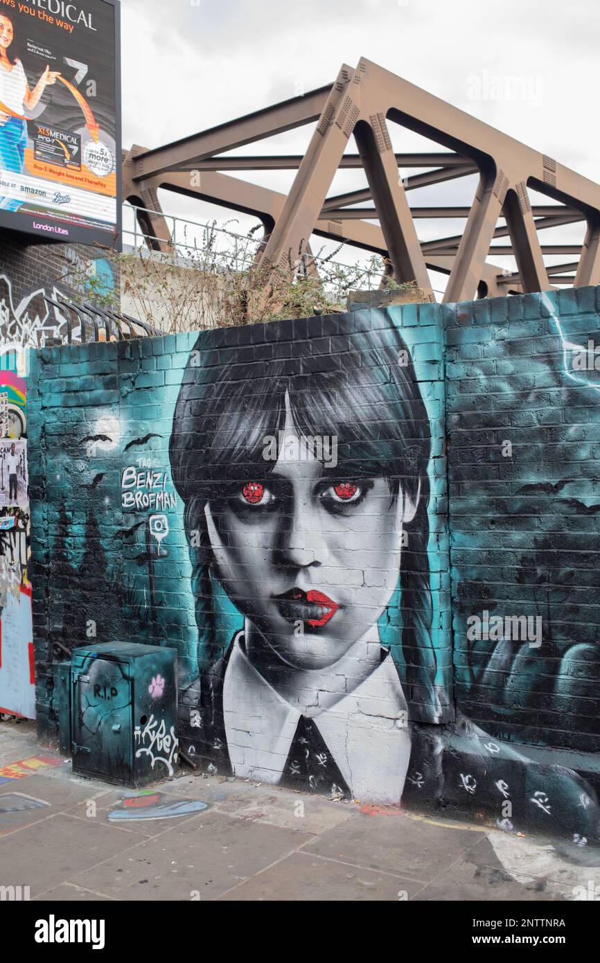 Street Art Wandgemälde von Wednesday Addams (Jenna Ortega) vom Graffiti-Künstler Benzi Brofman, Brick Lane, East London, England. Stockfoto