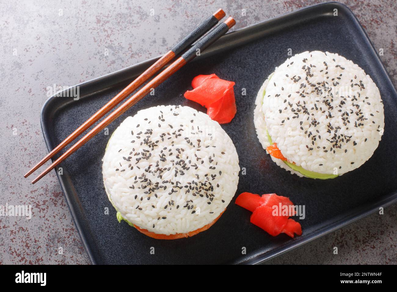 Hausgemachte asiatische Küche, glutenfreie Sushi-Lachs-Burger, Nahaufnahme auf einem Teller auf dem Tisch. Horizontale Draufsicht von oben Stockfoto