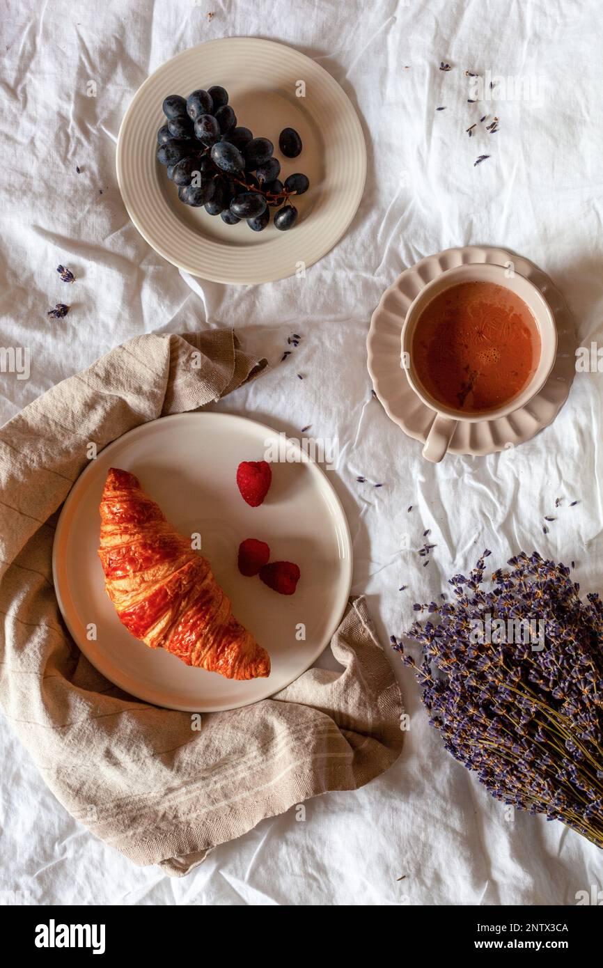 Traditionelles französisches Frühstück mit Croissant, Trauben und heißer Schokolade, Foto über Kopf Stockfoto