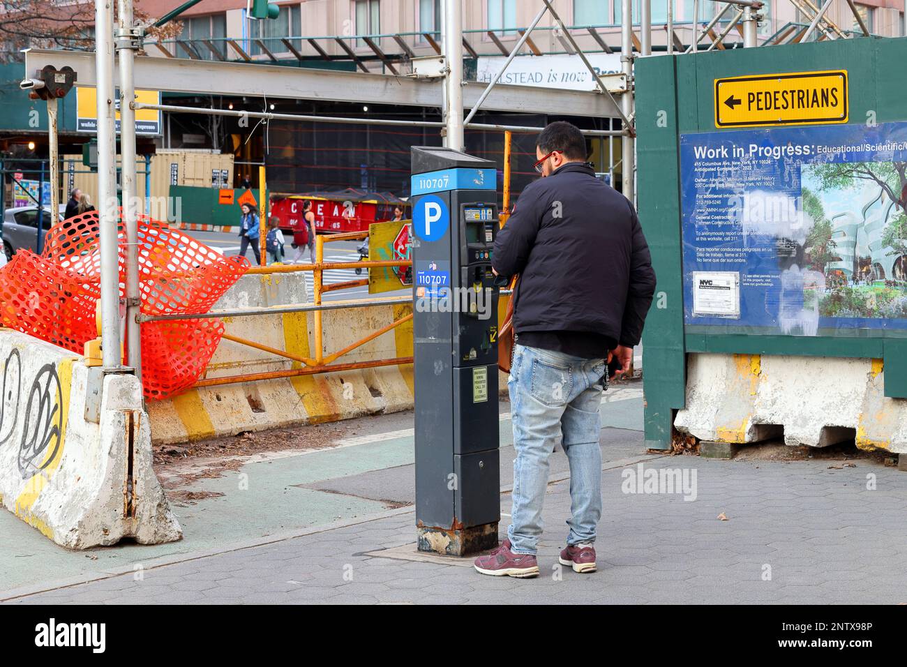 Eine Person, die eine Parkuhr in NYC verwendet. Das Münzmessgerät druckt einen Zahlungsbeleg. Stockfoto