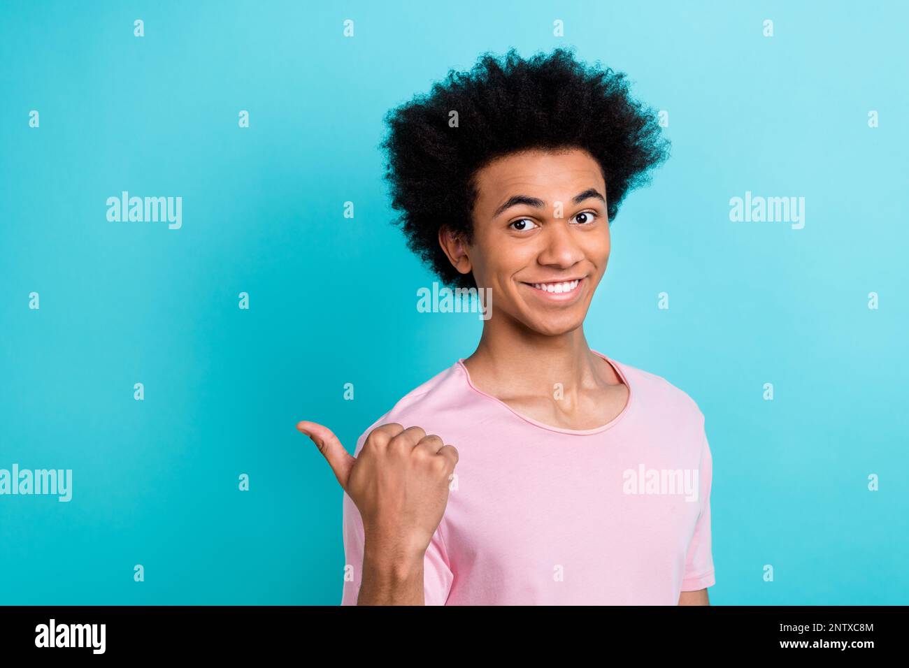 Das Foto eines positiven, fröhlichen Promoter-Typen, der mit den Fingern einen leeren Raum zeigt, empfiehlt einen neuen Stomatologie-Salon, isoliert auf zyanfarbenem Hintergrund Stockfoto
