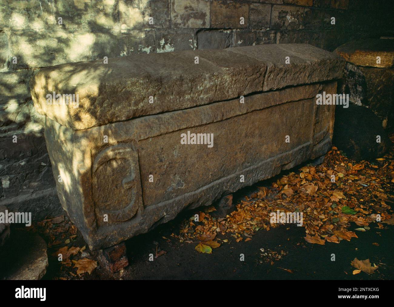 Ein römischer Steinsarg (Sarkophag) in einem Torbogen neben dem Eingang der Museum Street zu den York Museum Gardens, North Yorkshire, England, Großbritannien. Stockfoto