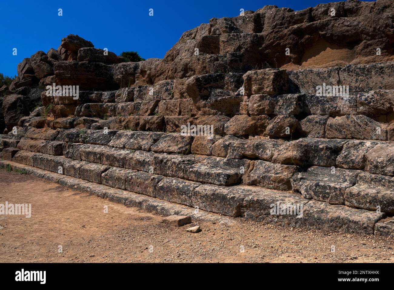 Die Treppen hinauf zum Boden des riesigen antiken griechischen Tempels des Olympischen Zeus im Tal der Tempel in Agrigento, Sizilien, Italien, werden von heruntergefallenen Steinblöcken und Säulentrommeln überwunden, die durch Erdbeben oder Kriege mit Karthago vertrieben wurden. Der Dorische Tempel, einer der größten der Welt, wurde um 480 v. Chr. erbaut, um die griechische Hafenstadt Akragas zu bedienen. Stockfoto