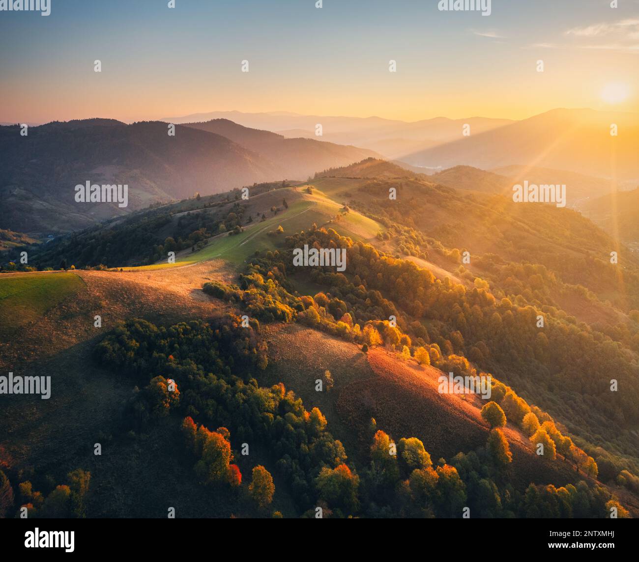 Blick aus der Vogelperspektive auf Hügel und Berge im Nebel bei Sonnenuntergang im Herbst Stockfoto