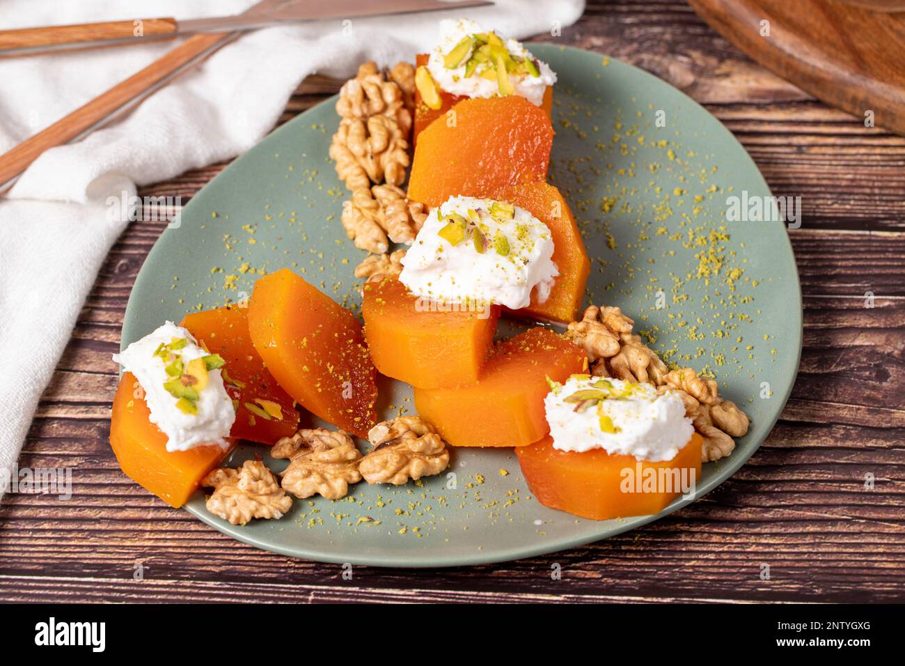 Cremiges Kürbis-Dessert. Süße türkische Ramadan-Delikatessen. Kürbis-Dessert mit Sorbet auf grauem Hintergrund. Stockfoto