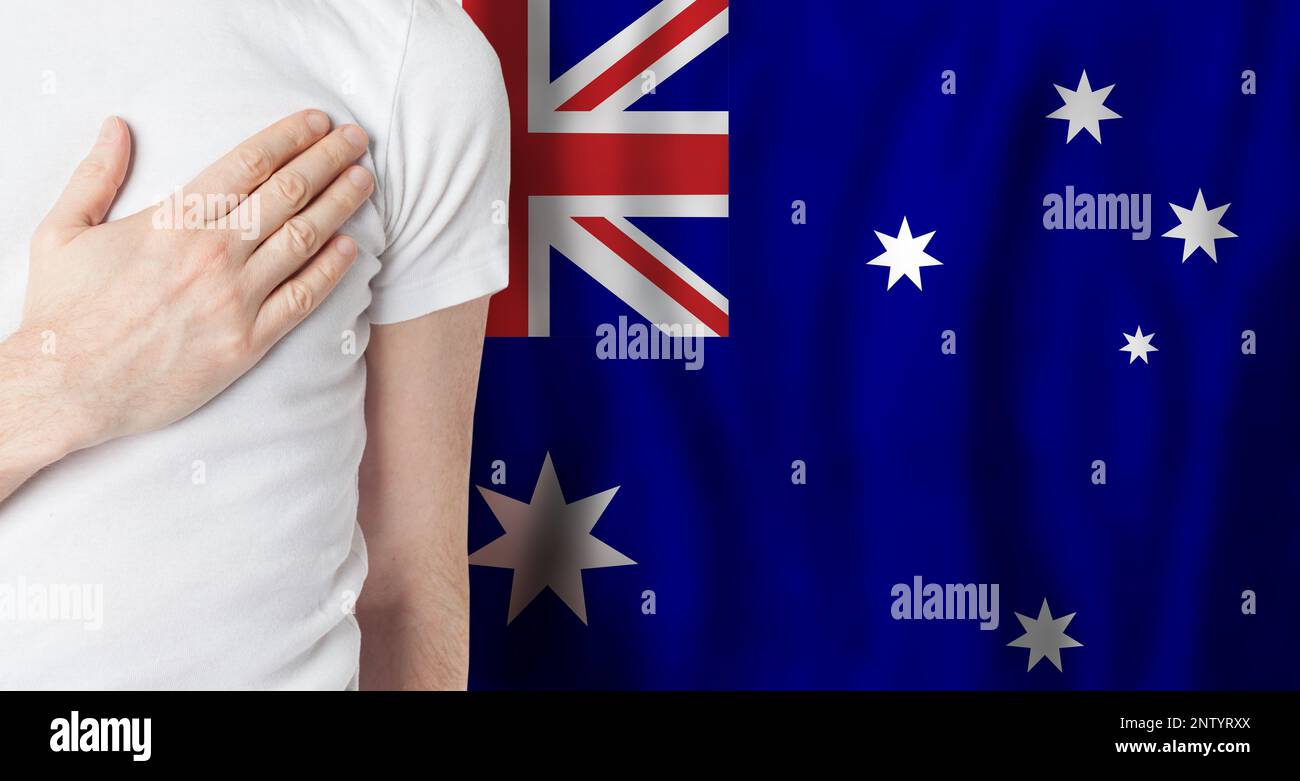 Australier mit Hand am Herzen auf dem Hintergrund der australischen Flagge. Patriotismus, Land, National, Pride-Konzept Stockfoto