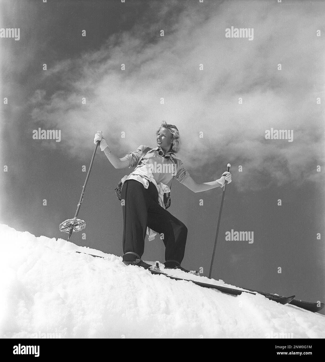 In den schneebedeckten Bergen 1940er. Olga Sjögren aus Stockholm ist in der typischen Wintersportmode der 1940er Jahre gekleidet, wenn Sie den schneebedeckten Berg Kuoblatjåkko in Norrbotten Schweden besteigen. Der letzte von sieben Bergen, die sie erklommen hat, um die Auszeichnung zu erhalten: Die sieben Gipfel. Sie verbrachte 60 Stunden und stieg insgesamt 6558 Meter hoch, nachdem sie fertig war. Schweden 1943 Kristoffersson Ref H137-6 Stockfoto
