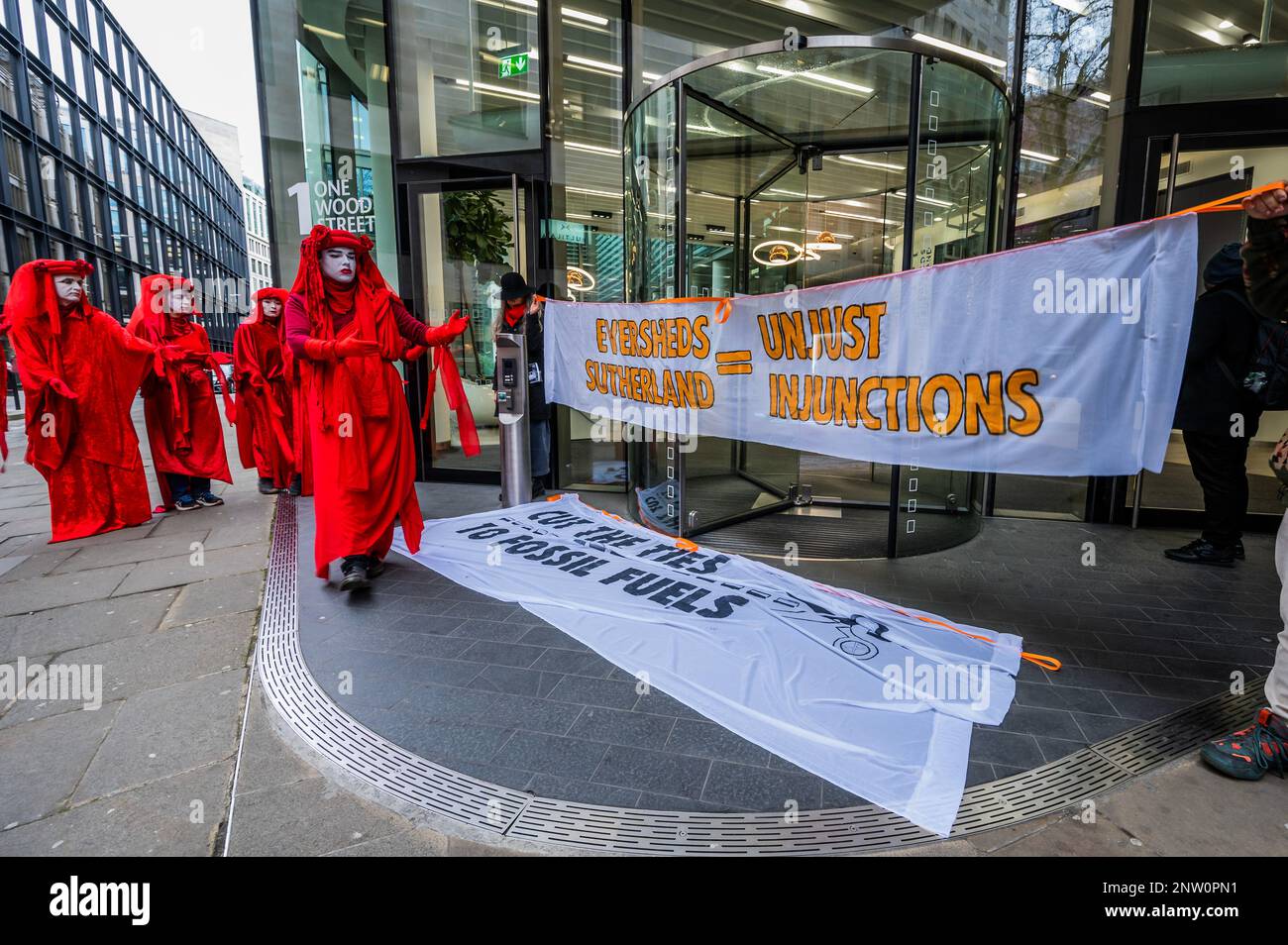 London, Großbritannien. 28. Februar 2023. Demonstranten, darunter die Roten Rebellen, versammeln sich vor den Büros von Eversheds, einer der großen Anwaltskanzleien der Stadt - die Kampagne des Extinction Rebellion, die Verbindungen zu Fossil Fuels zu kappen - und protestieren dagegen, dass friedliche Proteste durch Unterlassungsverfügungen von Anwaltskanzleien verhindert werden, die große Ölvorkommen wie Exxon und Bauunternehmer ermöglichen Wie HS2, um die Zerstörung des Planeten fortzusetzen. Kredit: Guy Bell/Alamy Live News Stockfoto