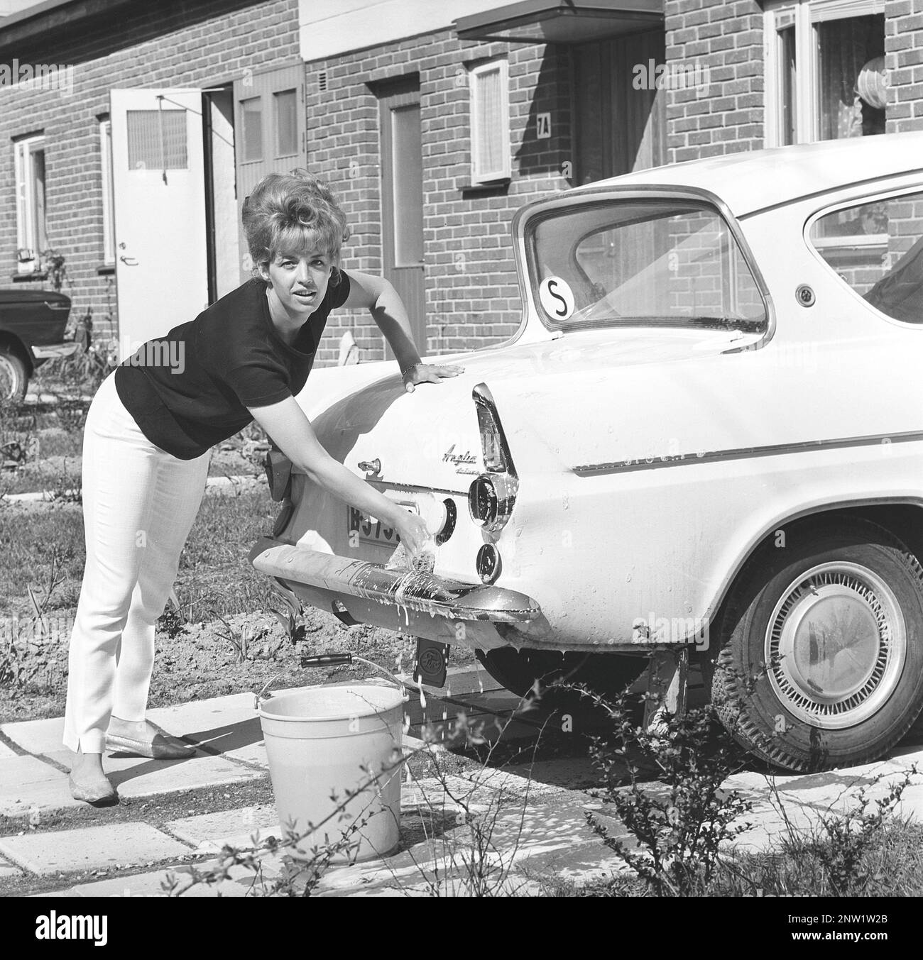 In den 1960er Jahren. Schauspielerin Lill-Babs wäscht ihr Auto, ein Ford Anglia. Schweden 1964 Ref. BV19-4 Stockfoto