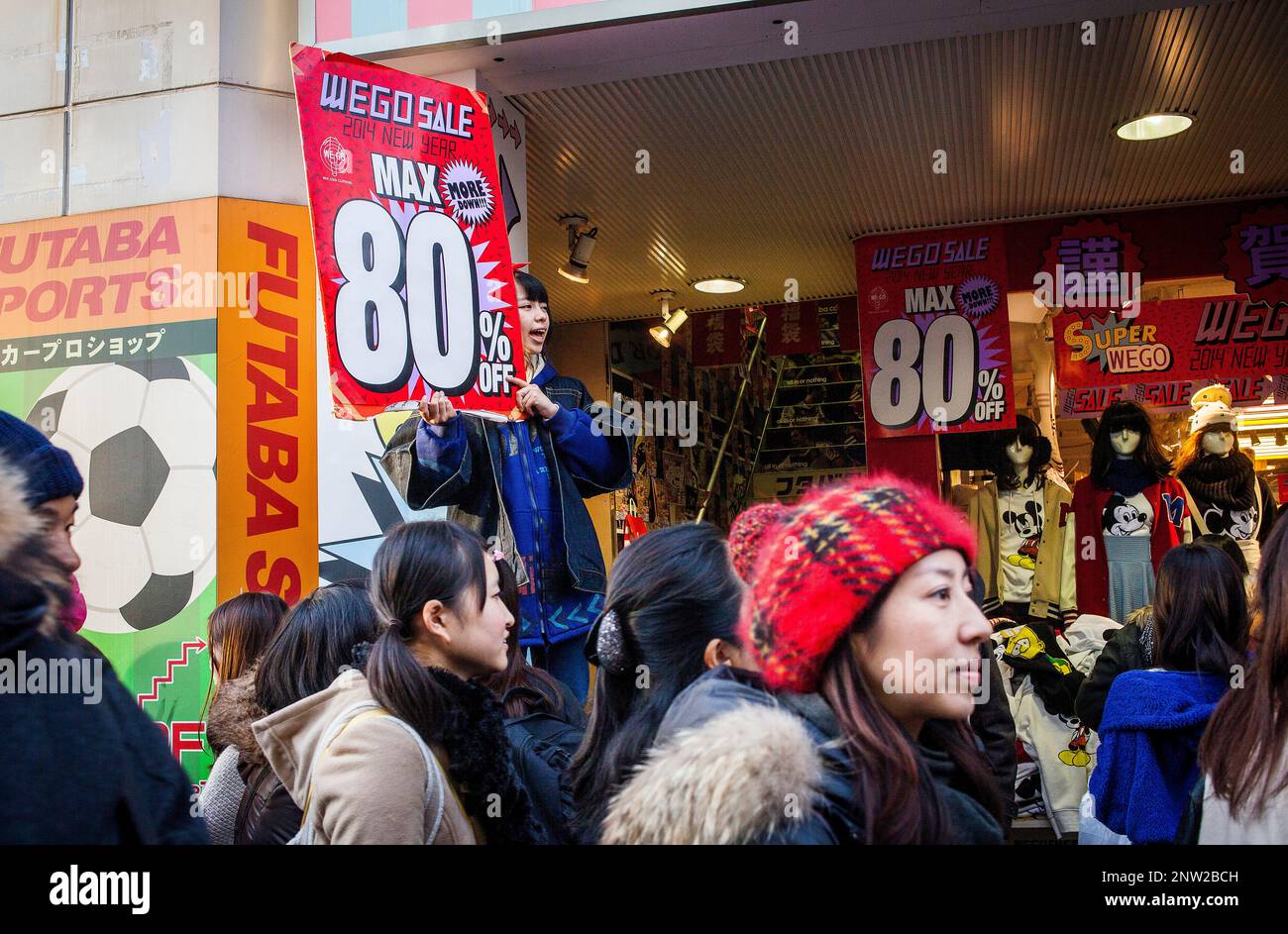 Ein Mädchen, das "Prices" vor der Tür von Futaba Sports, Takeshita Street, Sopping Street, in Omotesando, Tokio, Japan, Stockfoto