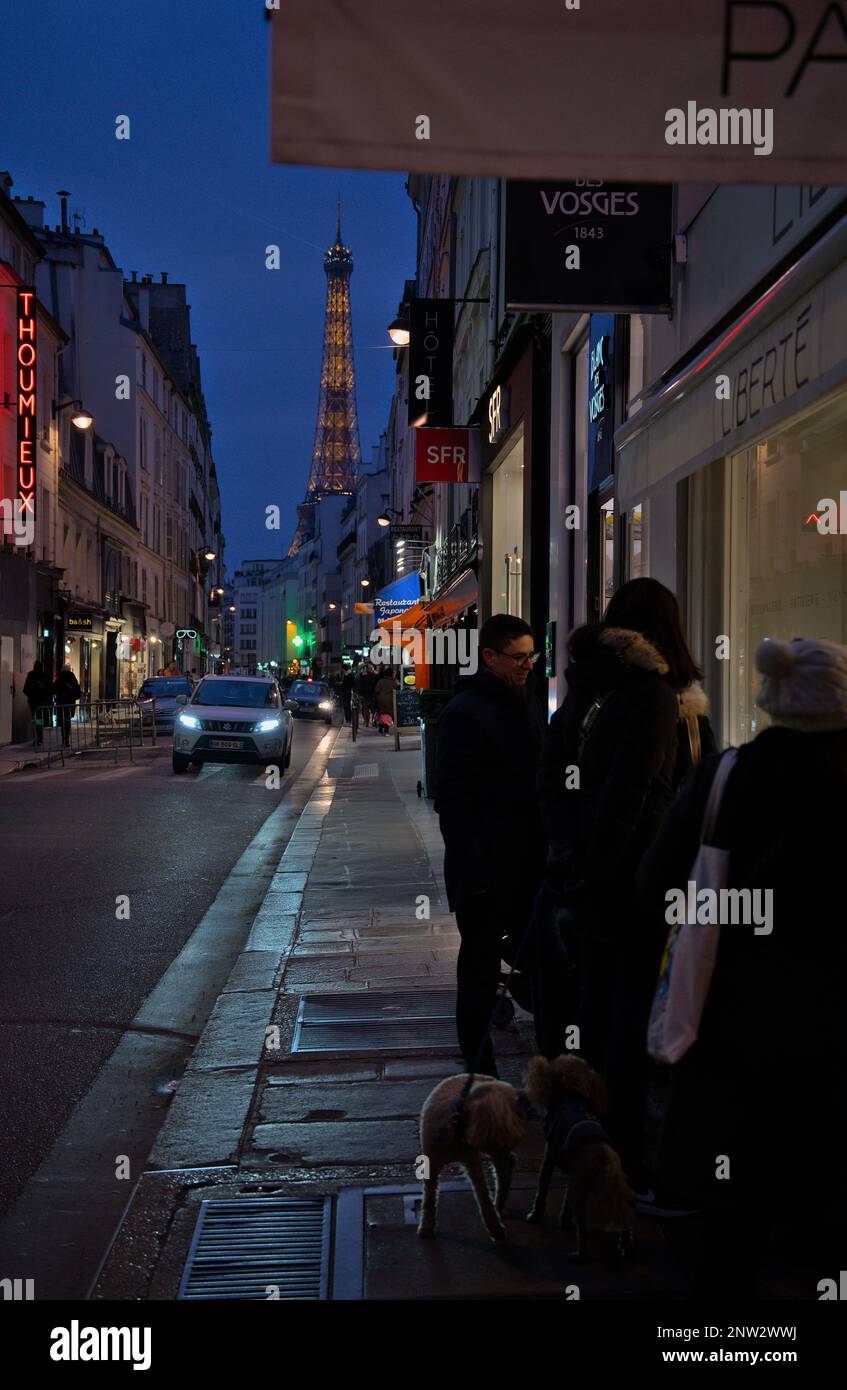 Man geht nachts in Richtung Eiffelturm. Leute kaufen in Paris Stockfoto