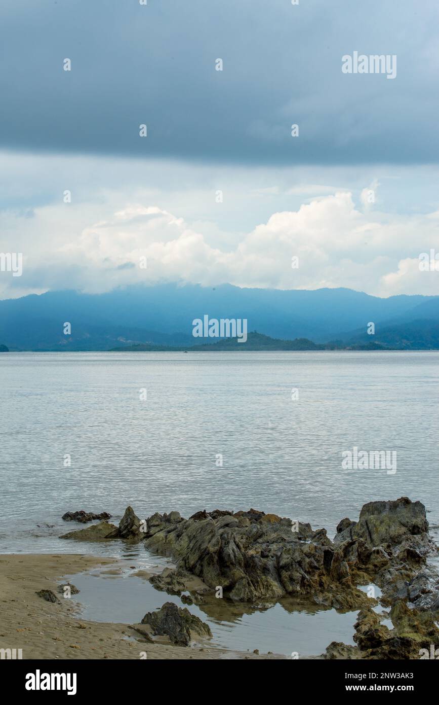 Das Foto bietet einen atemberaubenden Blick auf einen ruhigen Strand mit kristallklarem Wasser und sanften Wellen, die am Ufer schlagen. Stockfoto