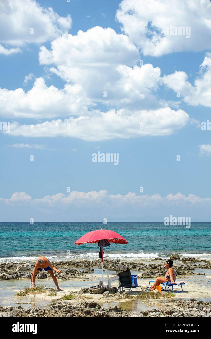 Ein paar Touristen am Strand Palude del Conte in der Nähe von Punta Prosciutto, am Ionischen Meer, Apulien, Italien Stockfoto