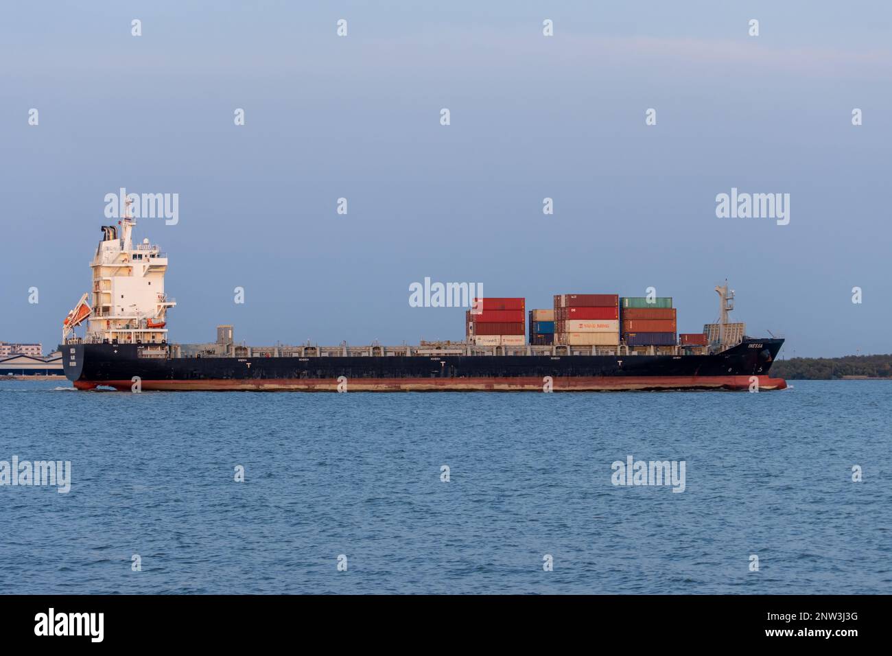 SAMUT PRAKAN, THAILAND, 10. FEBRUAR 2023, The Ship INESSA beladen mit Containern, segelt am Abend vom Fluss Chao Phraya auf ein offenes Meer Stockfoto