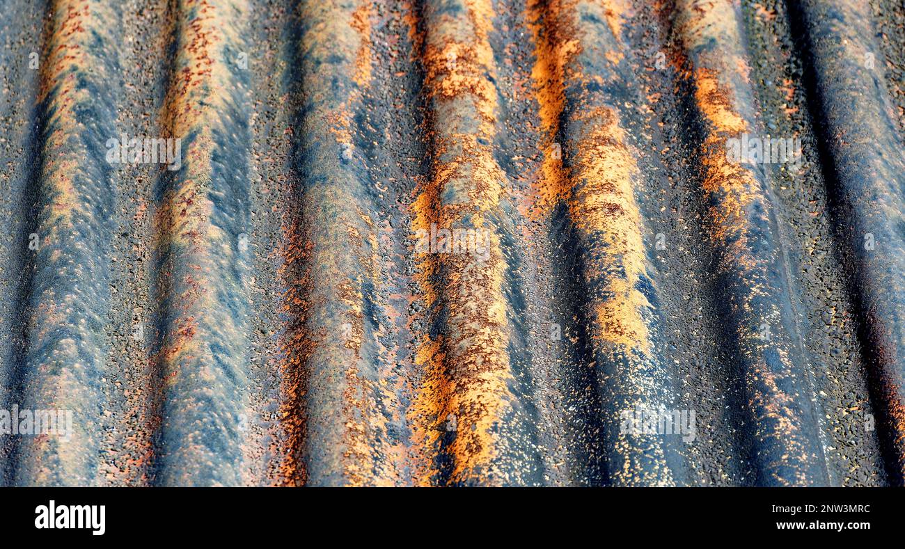 Farben und Konsistenz eines alten verrosteten Welleisendachs Stockfoto