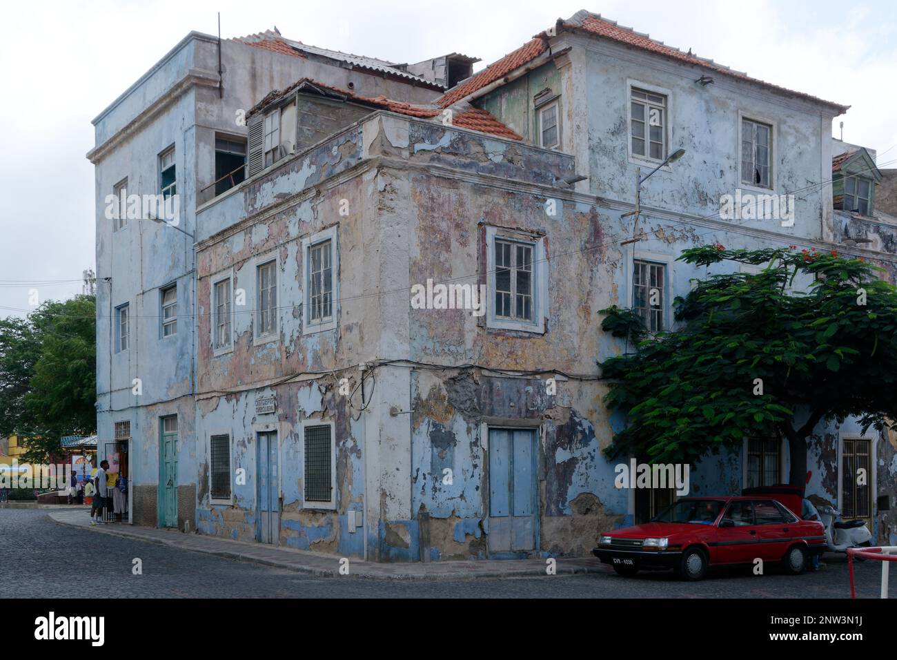 Ein altes Gebäude in Porto Grande, das dringend einer Instandhaltung bedarf. Zusätzliche Hütte auf der Veranda im dritten Stock. Muss dringend gestrichen werden. Stockfoto