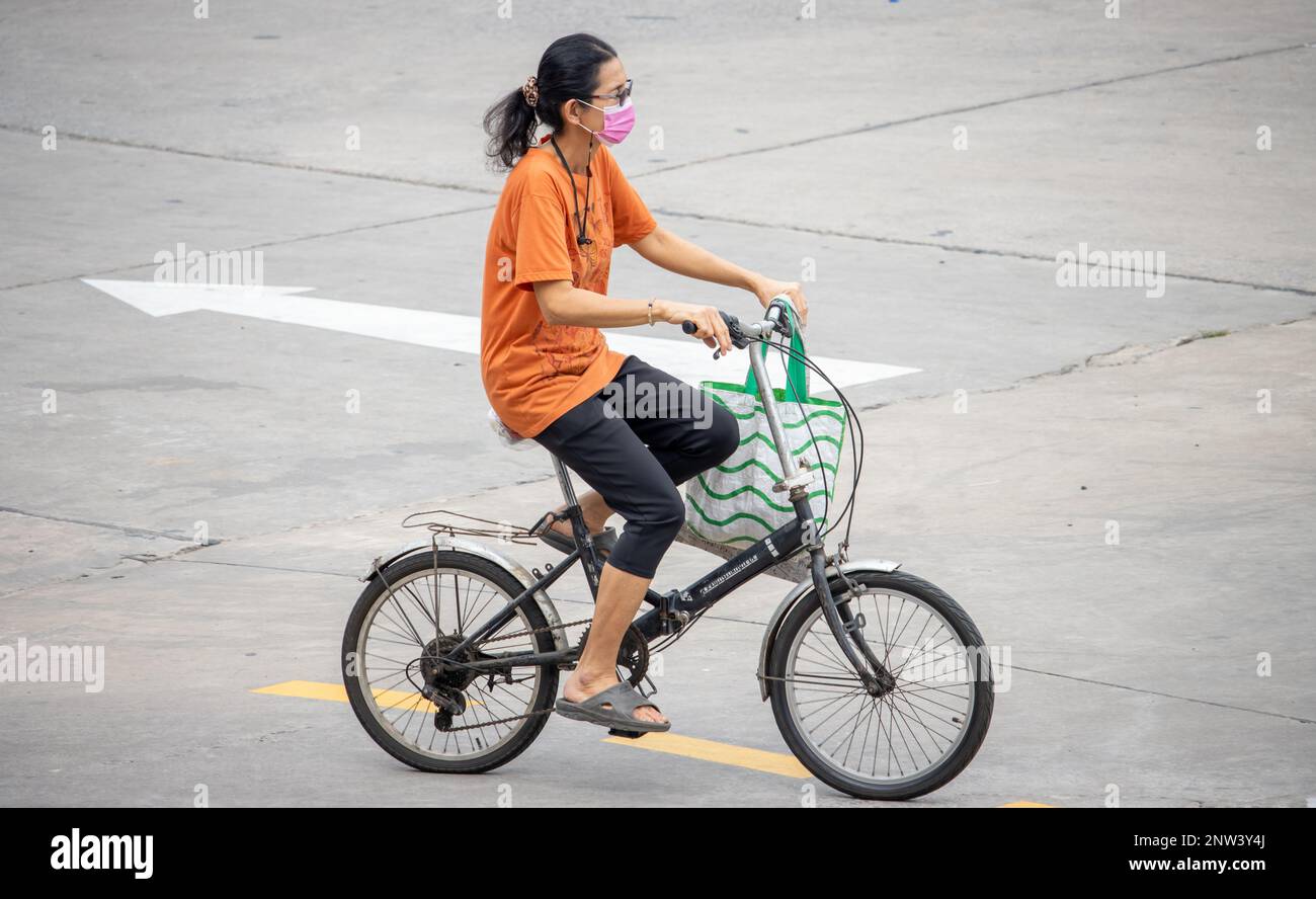 SAMUT PRAKAN, THAILAND, FEBRUAR 17 2023, Eine Frau fährt auf einem Fahrrad in der City Street. Stockfoto