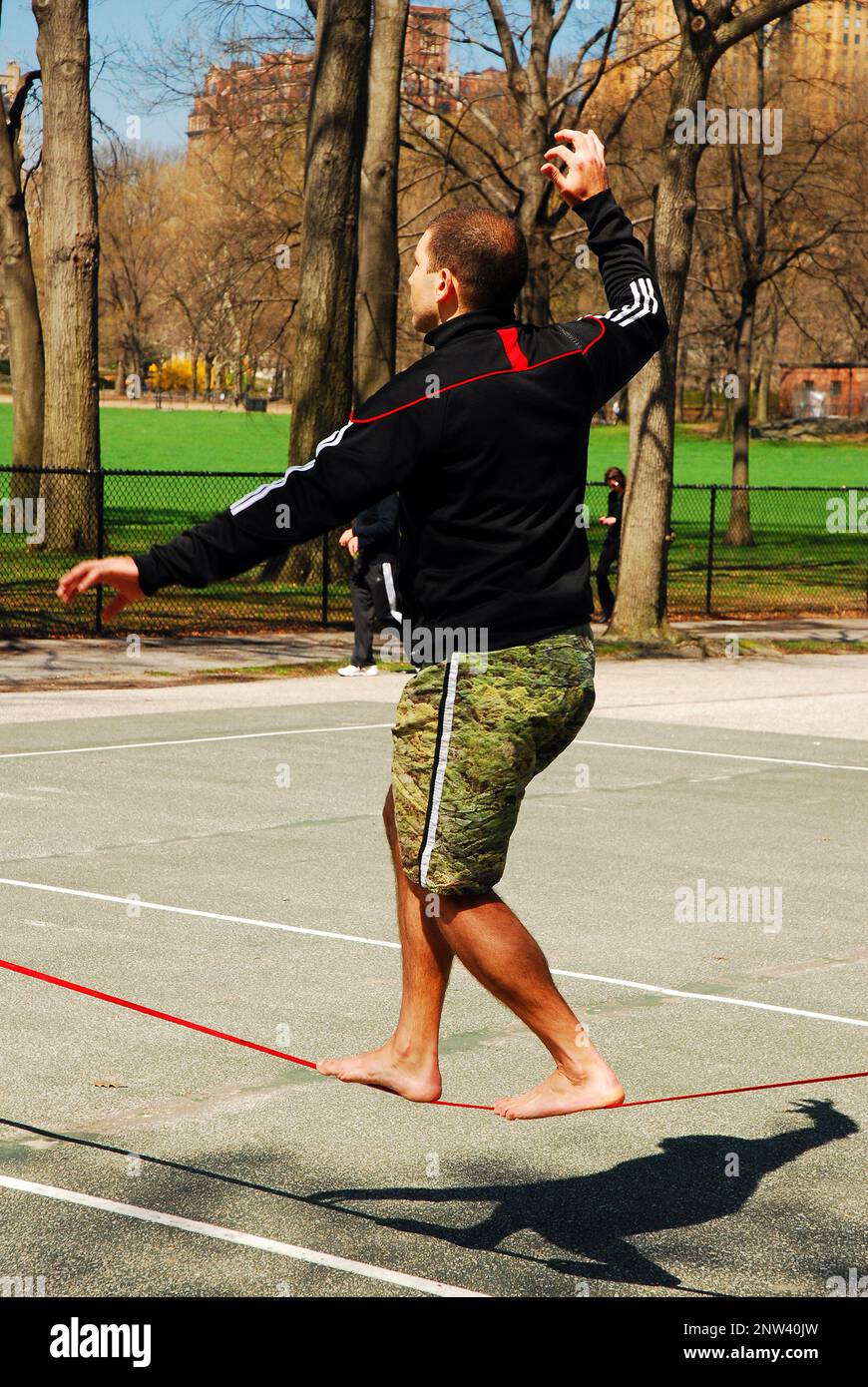 Ein junger Mann übt Slackline Walking im Central Park Stockfoto