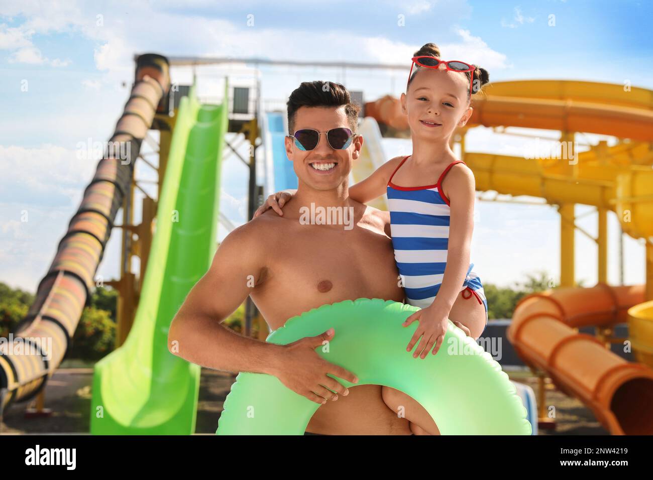 Vater und Tochter mit aufblasbarem Ring im Wasserpark. Familienurlaub Stockfoto
