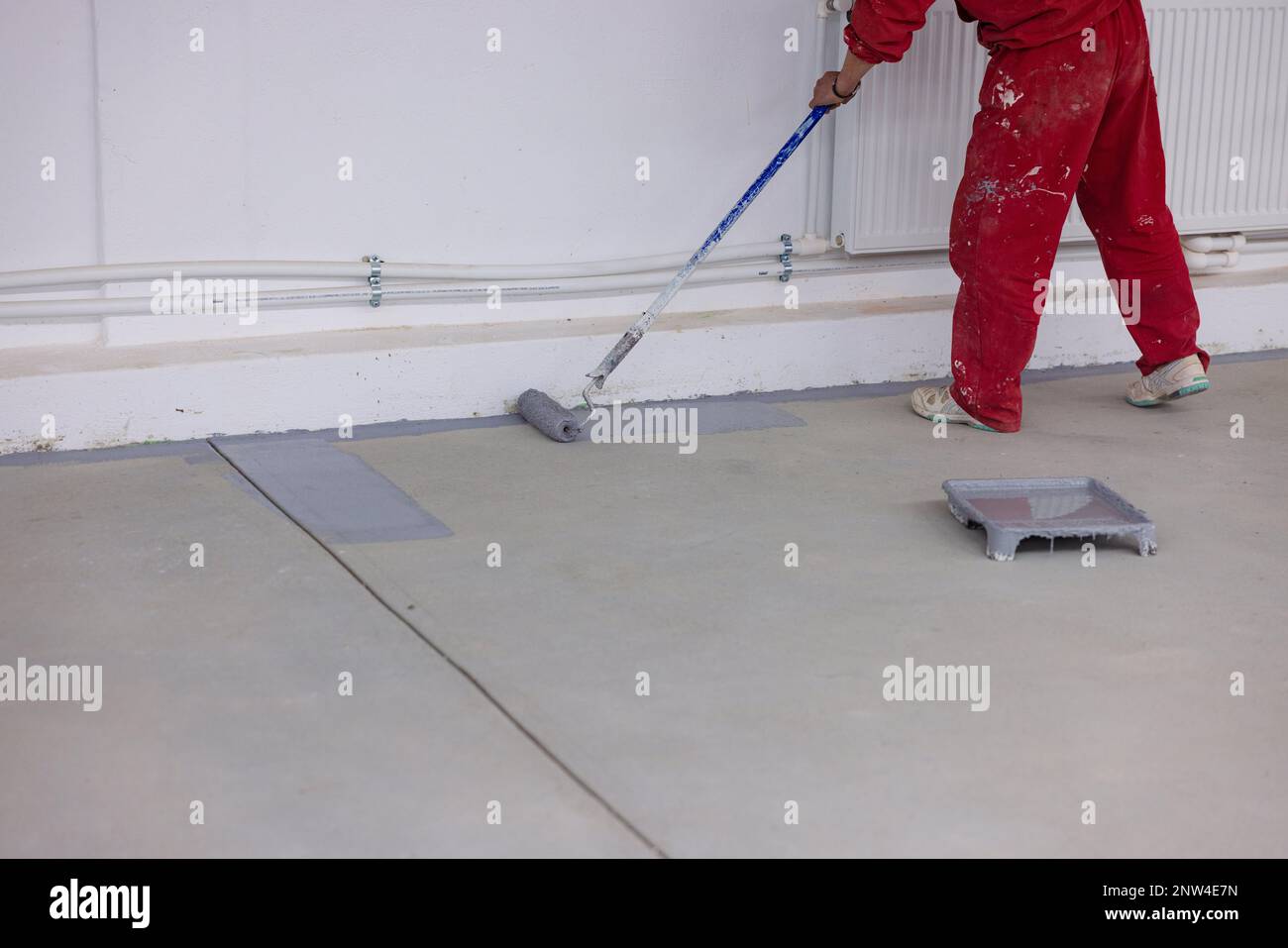Der Lackierer trägt in der Fabrik schweres graues Harz auf Stockfoto