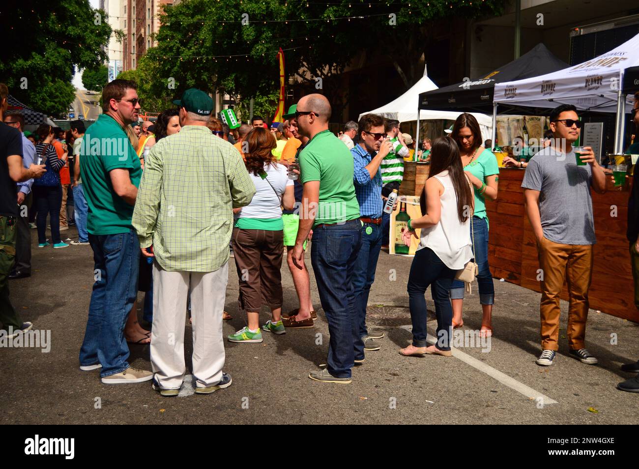 Freunde genießen es, beim St. Patrick's Day Festival in der Innenstadt von Los Angeles grün zu trinken und zu tragen Stockfoto