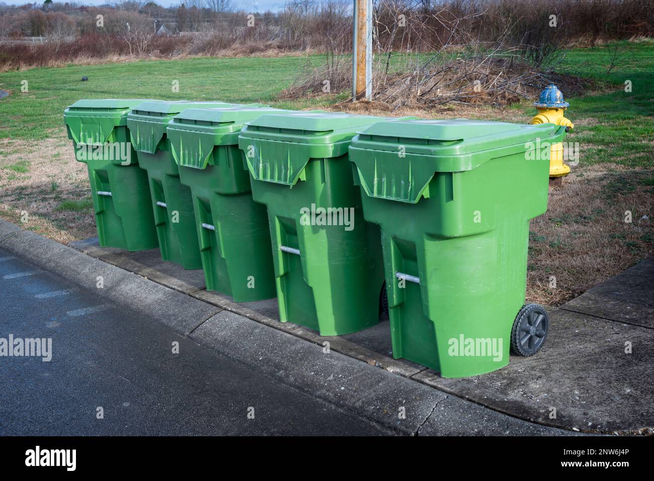 Horizontale Aufnahme einer Reihe von Mülltonnen am Tag des Kipplasters. Stockfoto