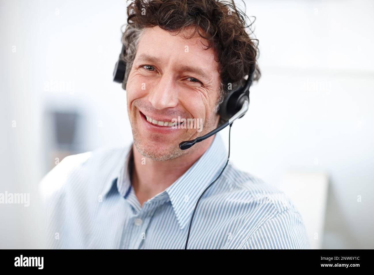 Was kann ich heute für Sie tun? Beschnittenes Porträt eines hübschen Callcenter-Bedieners im Büro. Stockfoto