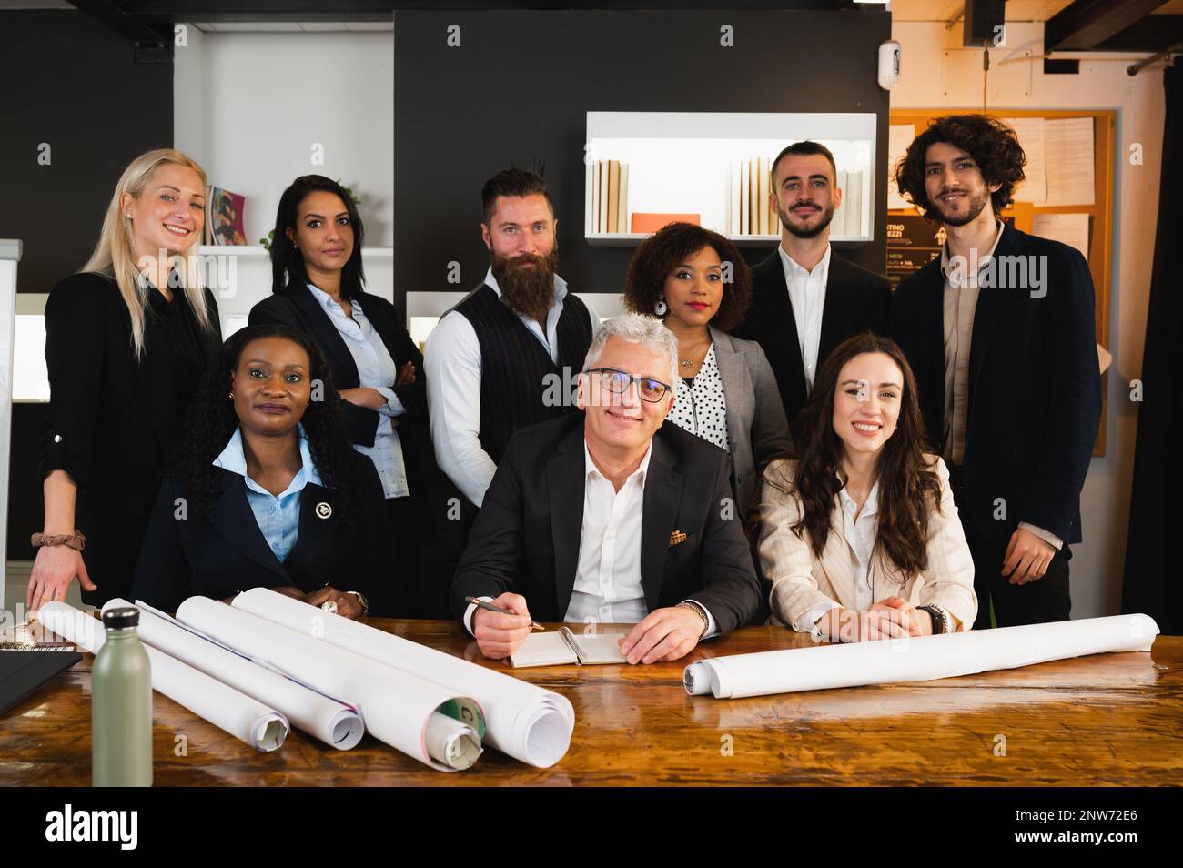 Portrait einer lächelnden Teamarbeit am Arbeitsplatz. Eine multiethnische Gruppe von Geschäftsleuten, die an einem Bauprojekt arbeiten. Stockfoto
