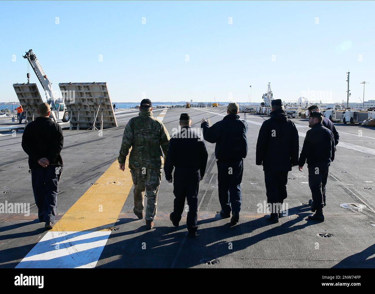 Aviation Boatswain’s Mate (Aircraft Handling) 2. Class Kyle Lilly, Center, aus Plano, Texas, angeschlossen an den erstklassigen Flugzeugträger USS Gerald R. Ford's (CVN 78) Air Department, gibt während einer Rundreise am 28. Januar 2023 die Nordic Defense Cooperation Master Chief Petty Officers of the Navy (MCPON) auf dem Flugdeck des Schiffes ein. Kommandomeister Bryan Davis war Gastgeber von MCPONs aus Finnland, Schweden, Dänemark und Norwegen, um sich mit dem Ford vertraut zu machen. Ford liegt im Hafen am Marinestützpunkt Norfolk für eine kontinuierliche planmäßige Wartung. Stockfoto