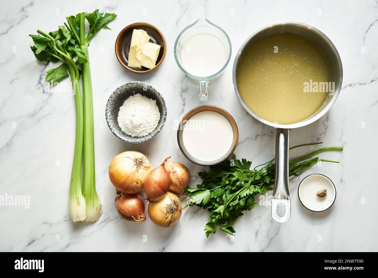 Weiße Zwiebelsuppe auf weißem Hintergrund von Butter und Zwiebeln bis hin zu Selleriebrühe und Sahne. Plus Muskatnuss Stockfoto